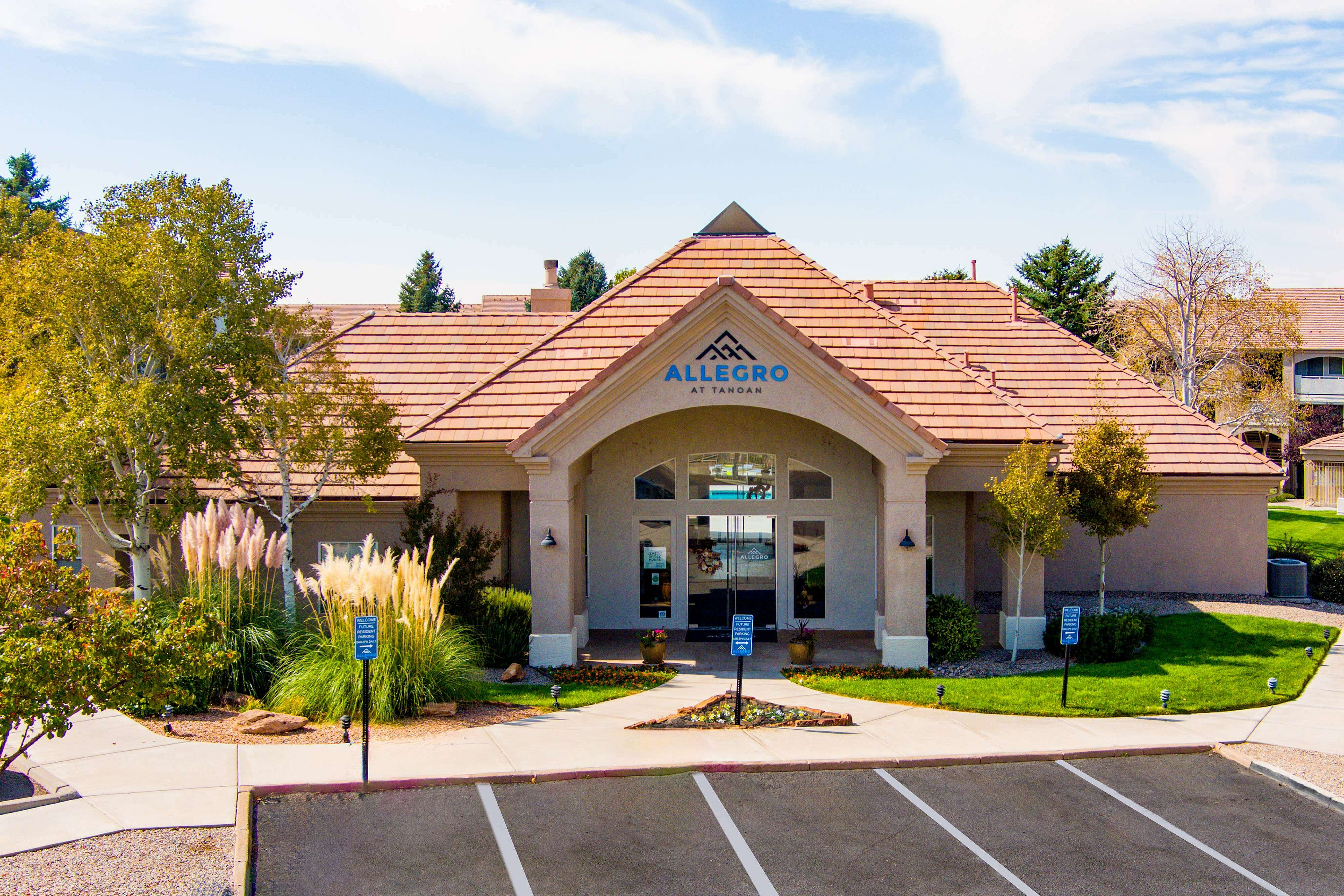 Charming entrance of Allegro at Tanoan with lush landscaping and elegant architecture.