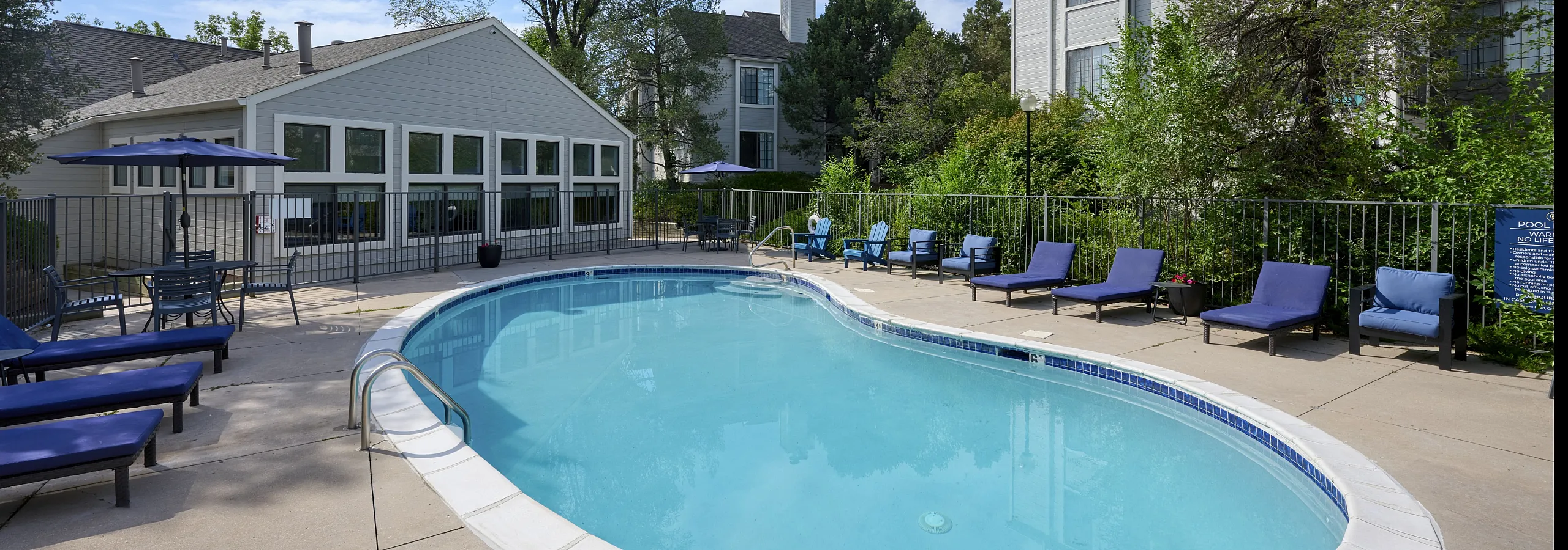 Inviting outdoor pool area with comfortable lounge chairs and lush greenery, perfect for relaxation and entertaining.