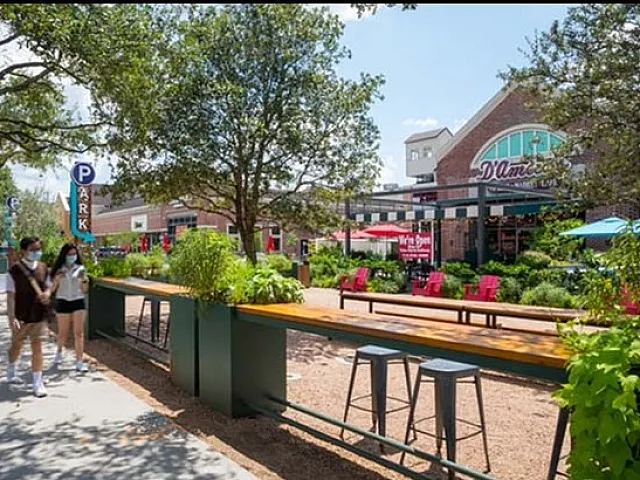 Charming outdoor urban scene featuring colorful seating, lush greenery, and vibrant café ambiance.