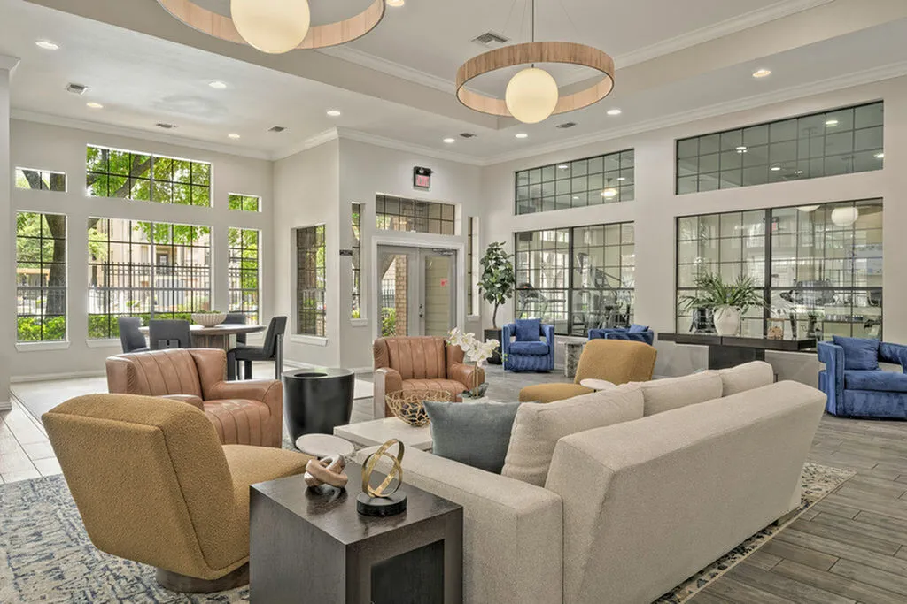 Elegant community lounge with plush seating, modern decor, and abundant natural light from large windows.