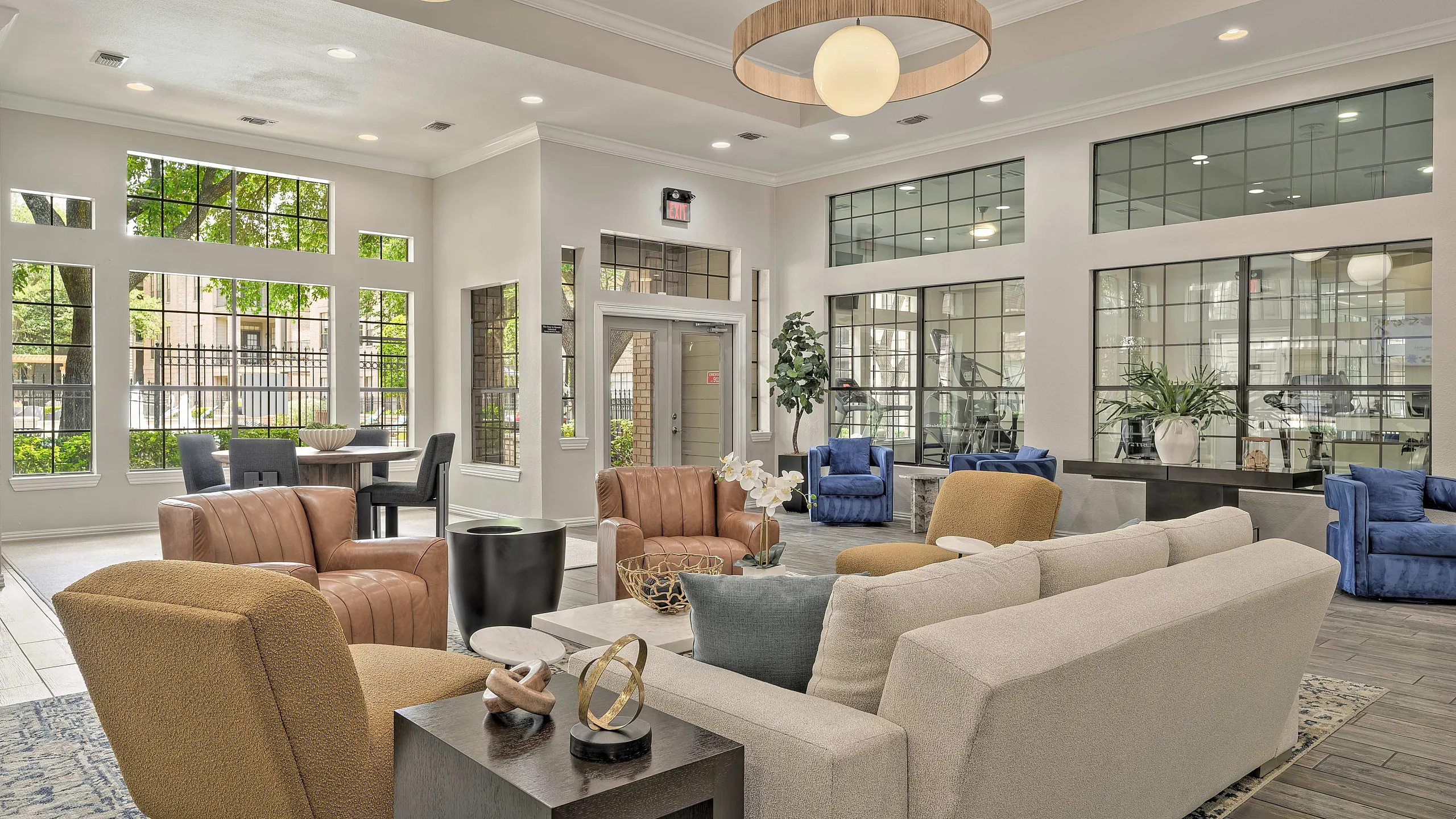Inviting lounge area with modern decor, featuring stylish seating and abundant natural light from large windows.