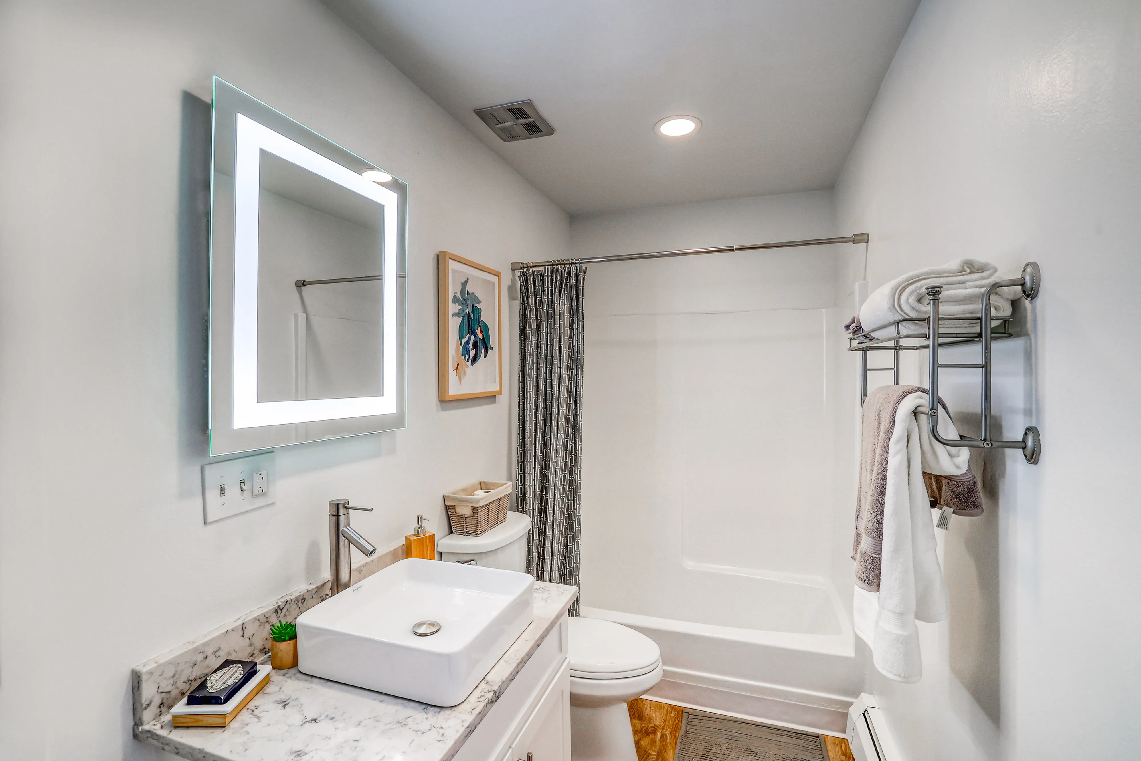 bathroom showcasing mirror with backlit lighting