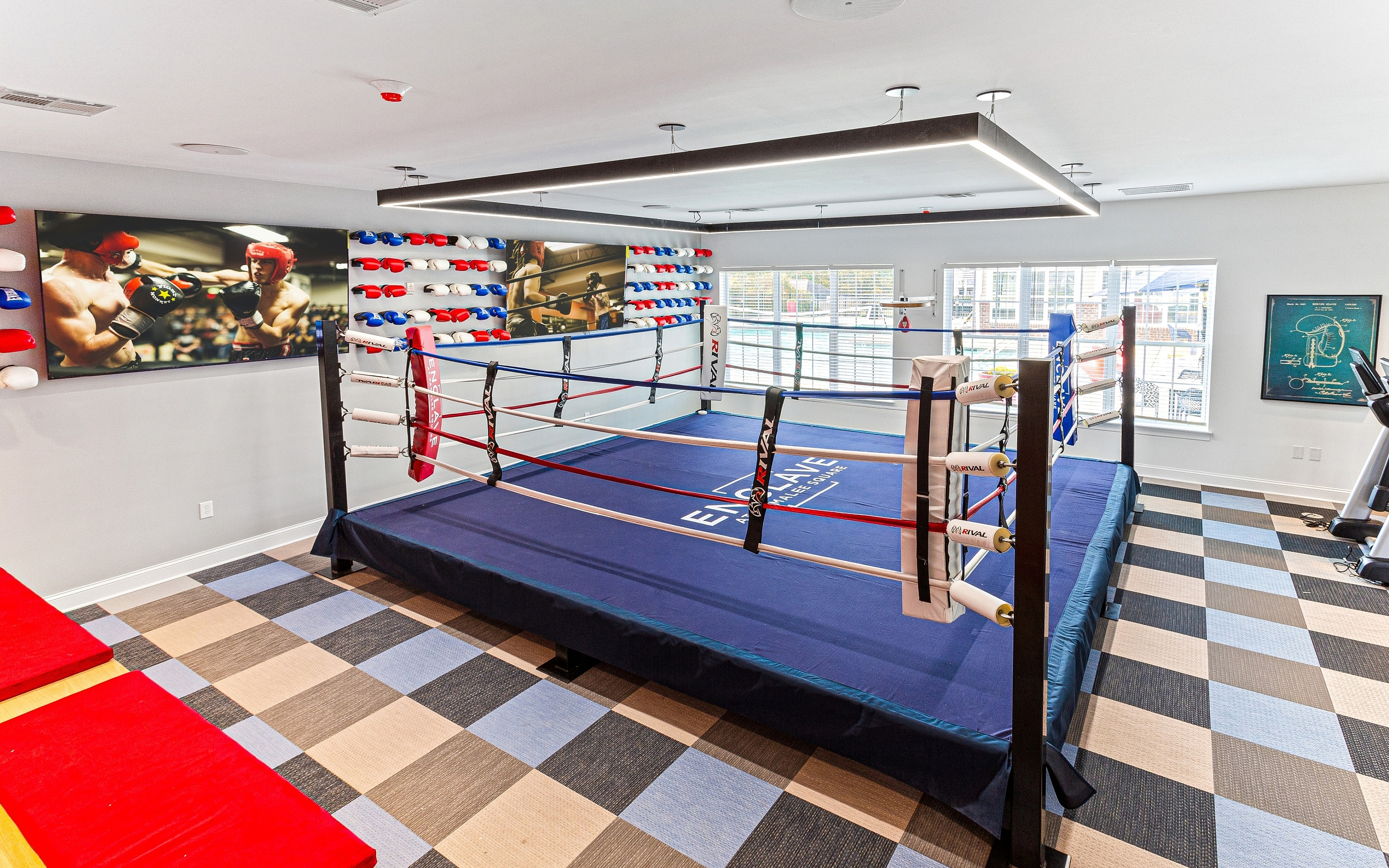 Modern luxury apartment boxing gym with a full-sized boxing ring and training equipment.