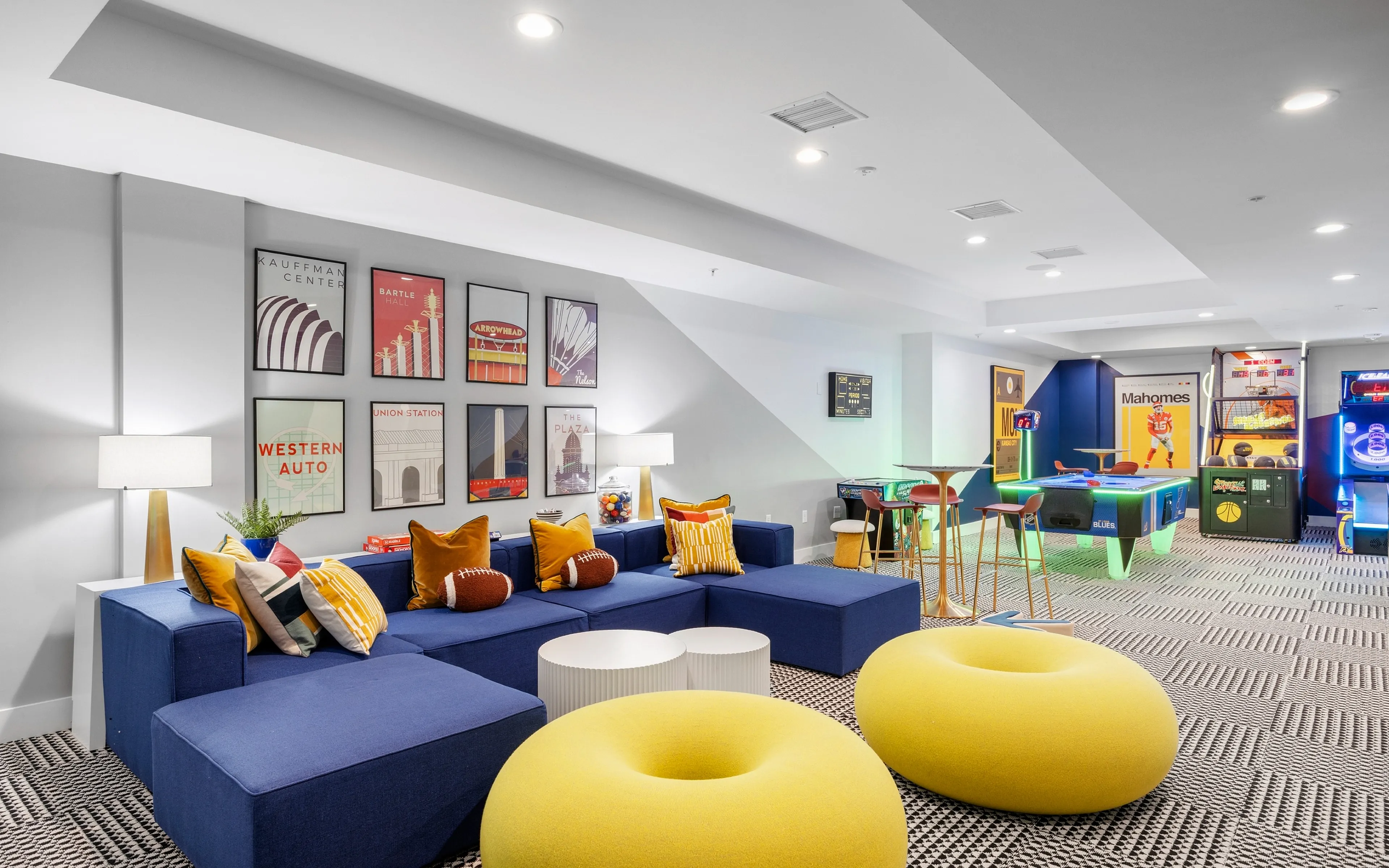 Stylish lounge with vibrant seating, framed art, and arcade games.
