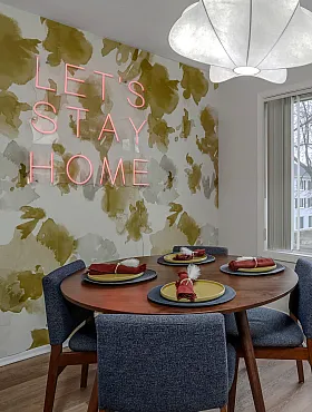 dining area with lets stay home neon light on wall