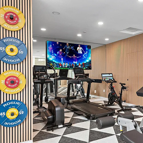 Modern fitness room with state-of-the-art equipment, vibrant decor, and motivational graphics for an energizing workout experience.