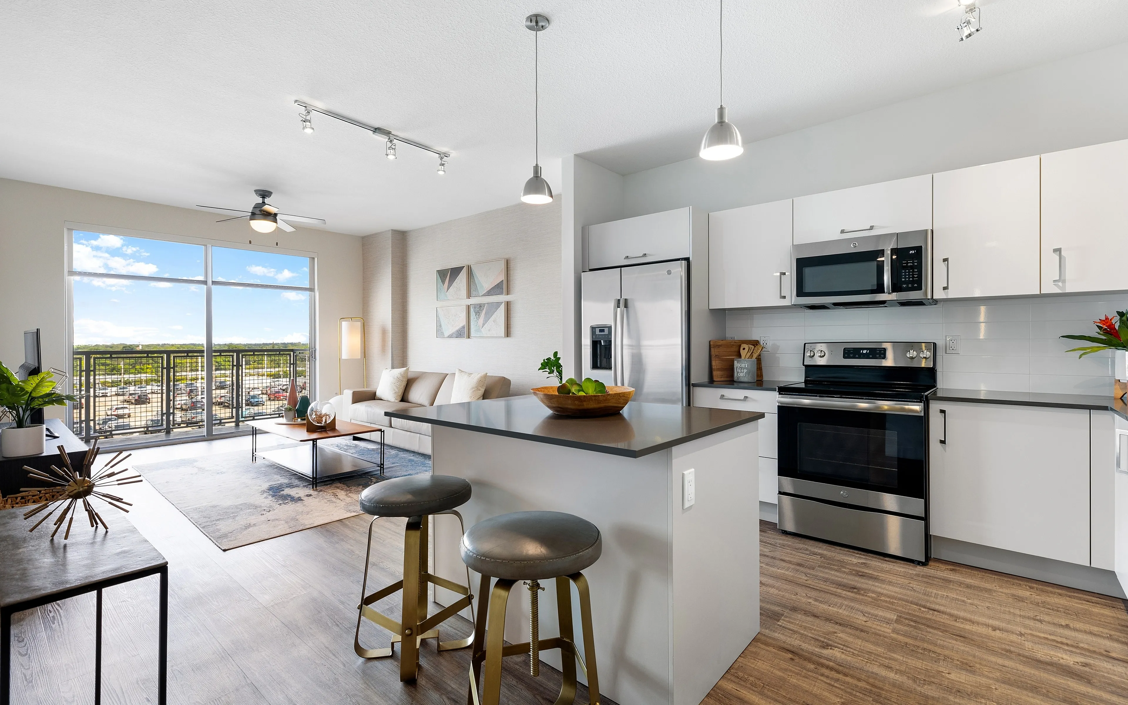 Bright and modern open-concept kitchen and living room with stylish furnishings, large windows, and a cozy seating area overlooking stunning views.