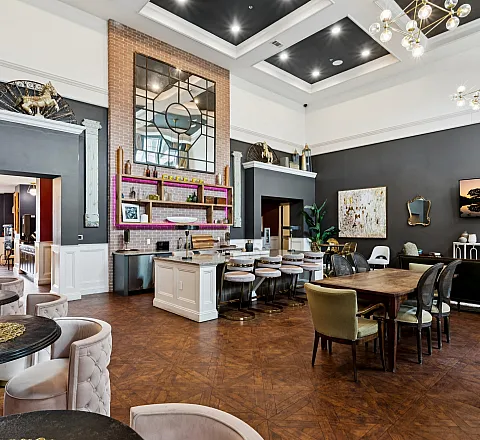 Elegant communal space featuring high ceilings, modern chandeliers, and chic d&eacute;cor with plush seating and a stylish open kitchen area.