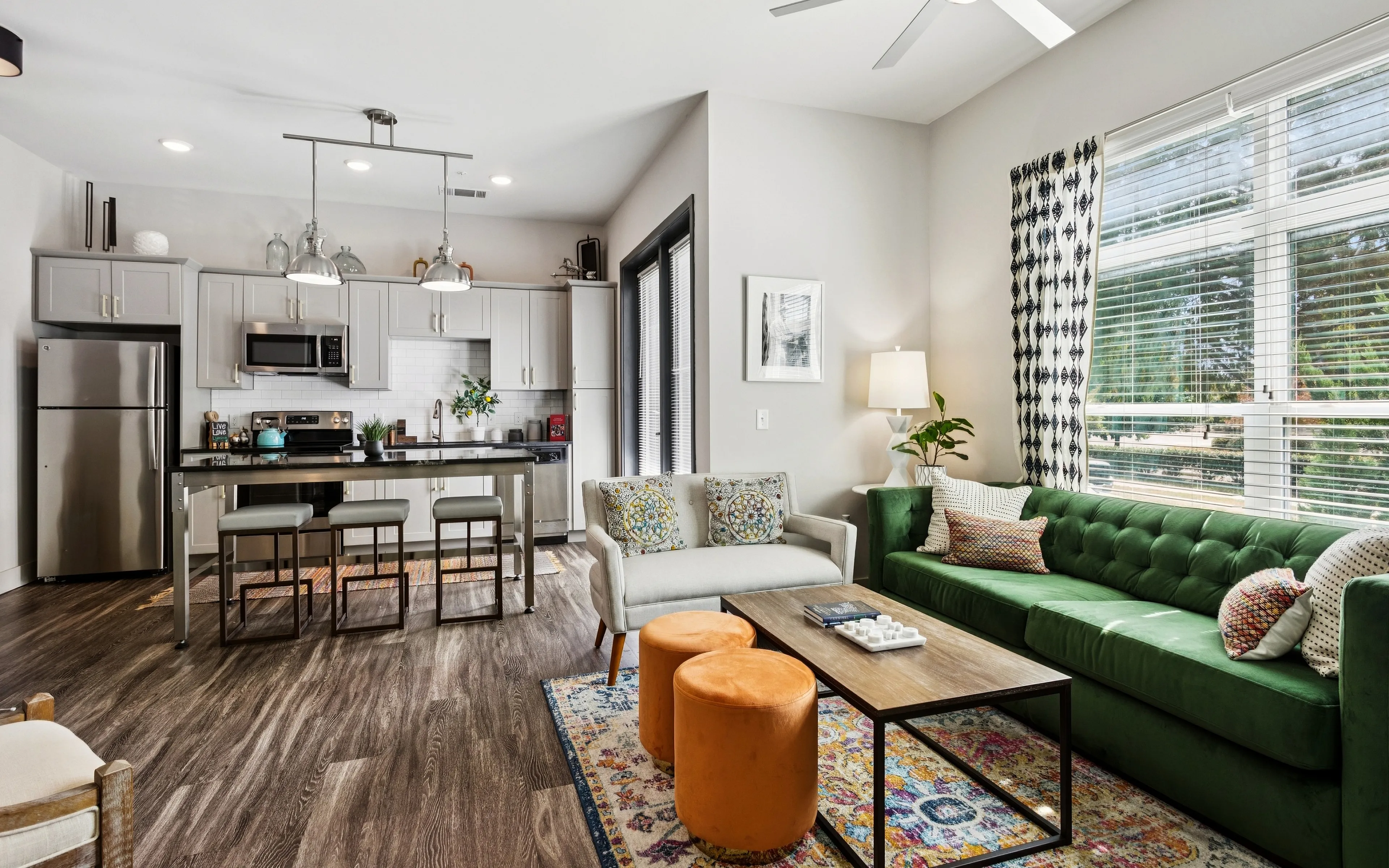 Bright and modern open-concept living space featuring a stylish kitchen, cozy seating area, and vibrant decor.