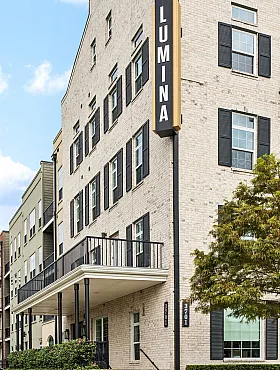 Charming and elegant brick apartment building featuring modern architectural design, large windows, and inviting balconies at Lumina Apartments.