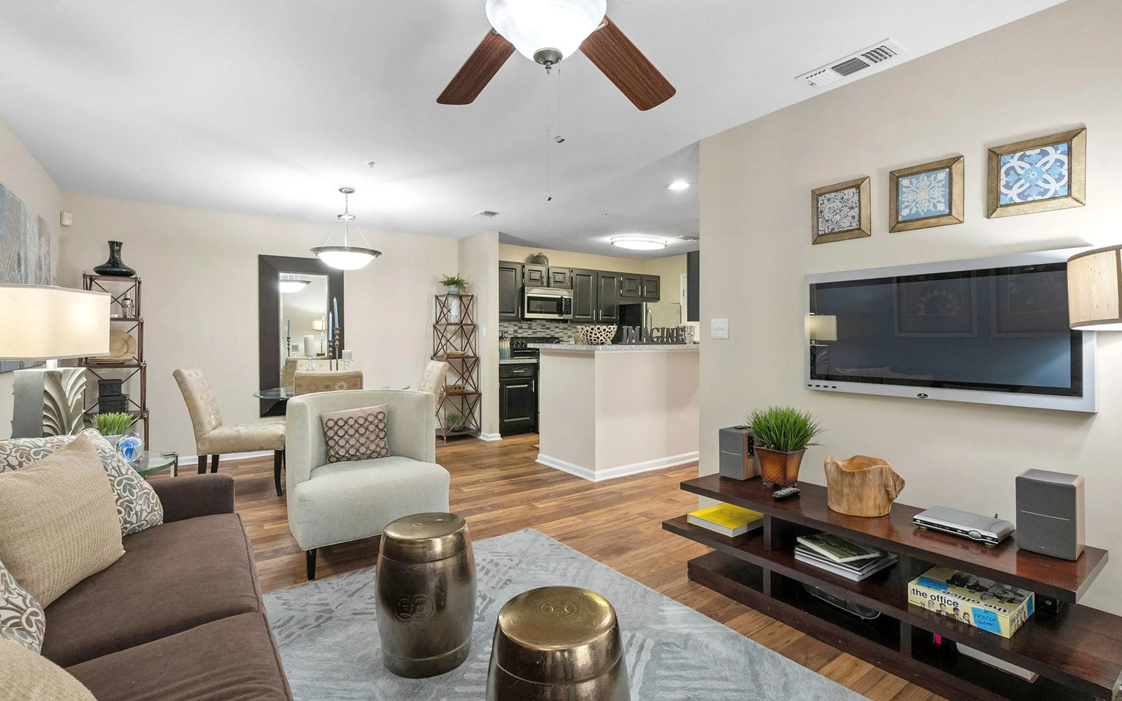 Elegant open-plan living area with cozy seating, modern kitchen, and stylish dining space, featuring hardwood floors and chic decor.