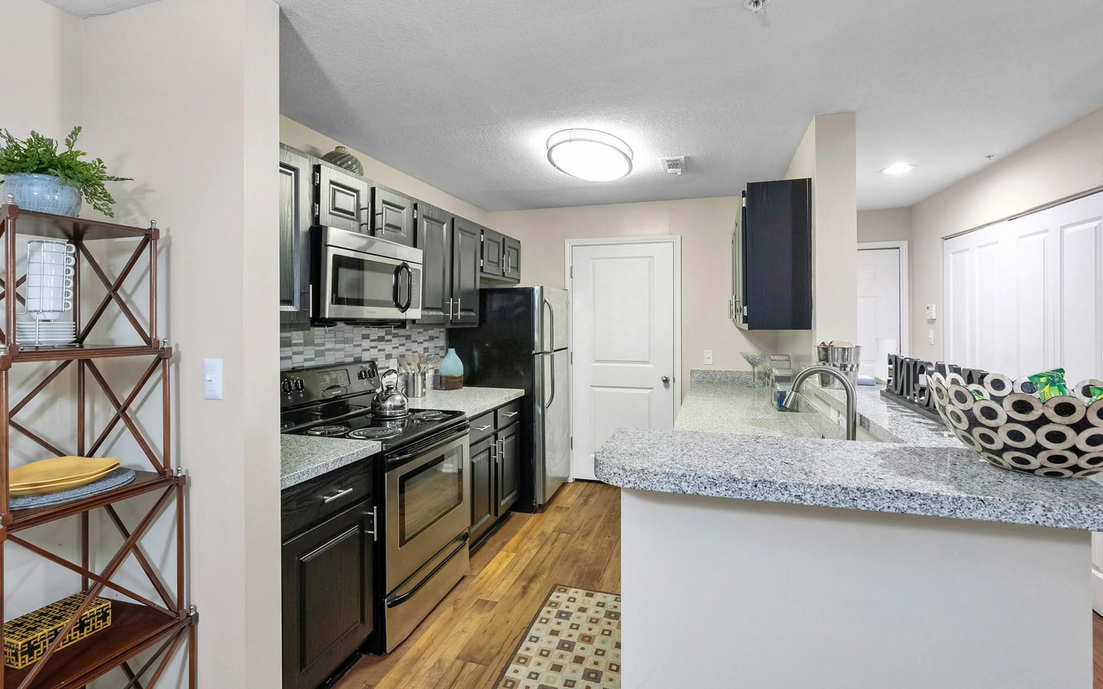 Modern kitchen with sleek dark cabinetry, stainless steel appliances, and elegant granite countertops.