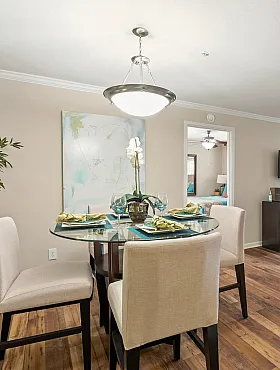 Elegant open living and dining area with modern decor, featuring hardwood floors, chic lighting, and stylish furnishings for a welcoming ambiance.
