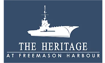 Elegant logo for The Heritage at Freemason Harbour, featuring a stylized white ship icon against a deep blue background.