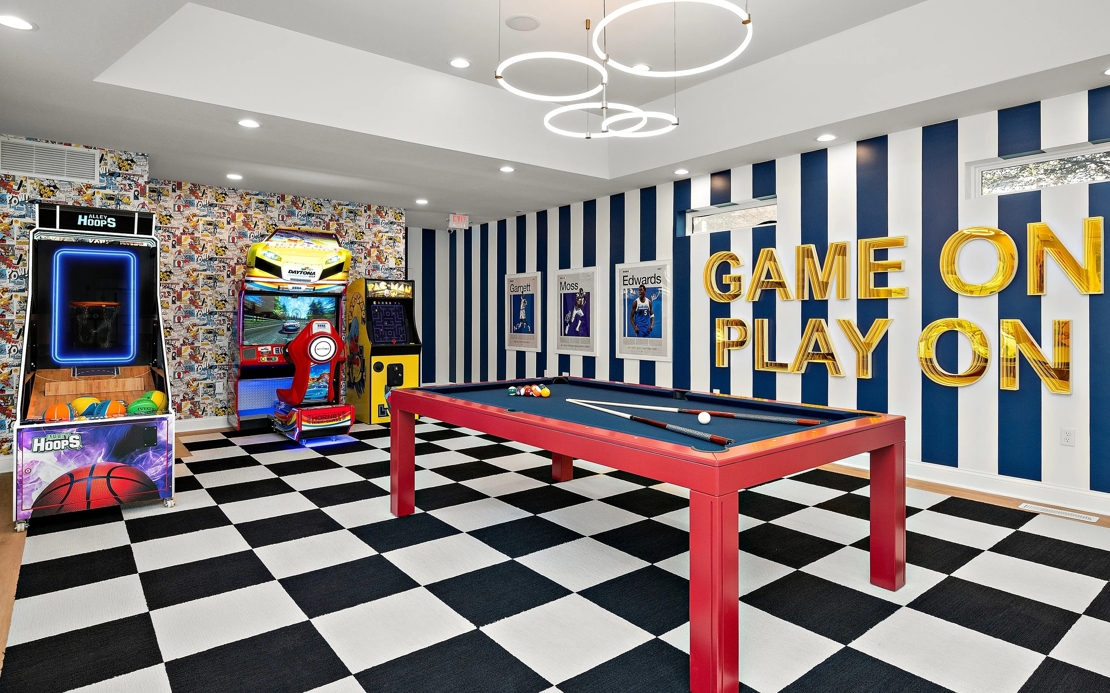 Vibrant entertainment room featuring a sleek pool table, arcade games, and bold decor with 'Game On, Play On' lettering.