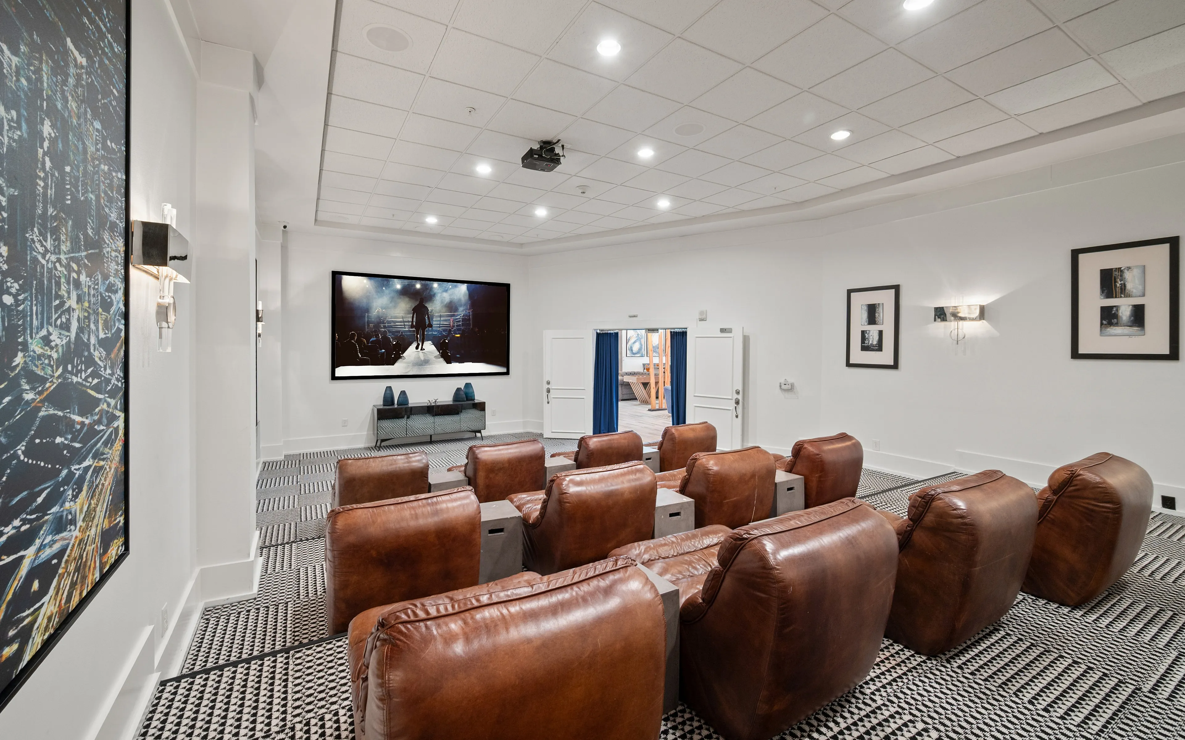 Luxurious home theater with plush leather seating, stylish decor, and large screen ideal for entertainment.