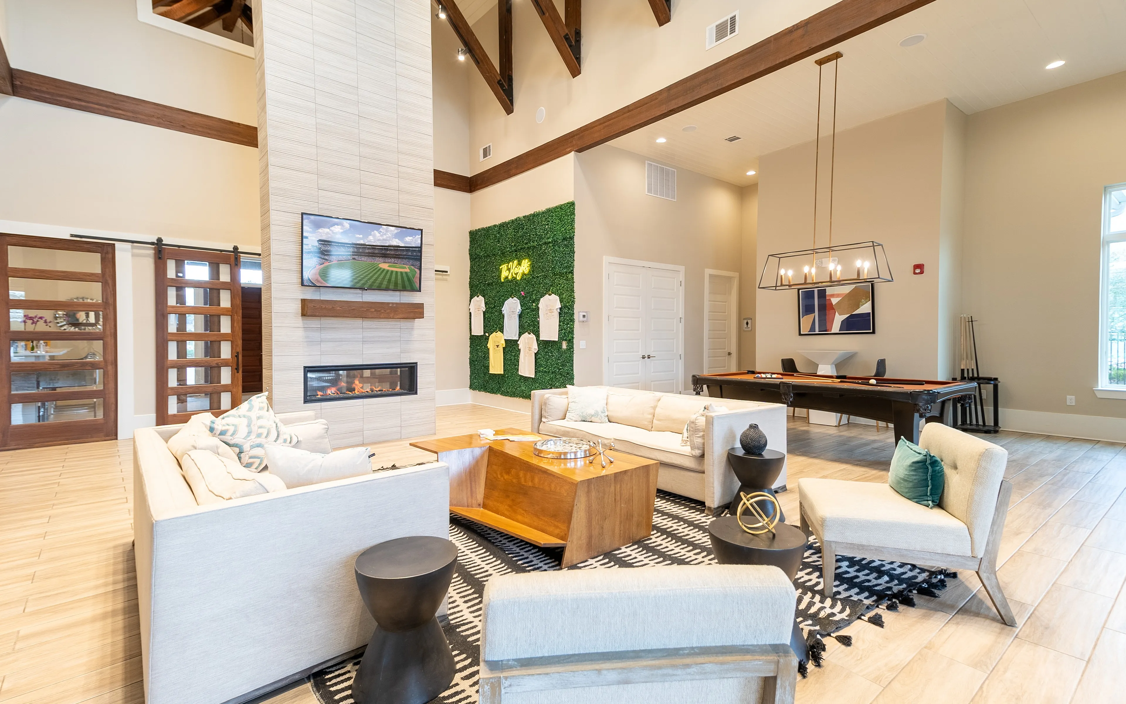 Luxurious living area with modern fireplace, cozy sofas, stylish decor, and a pool table, perfect for entertainment and relaxation.