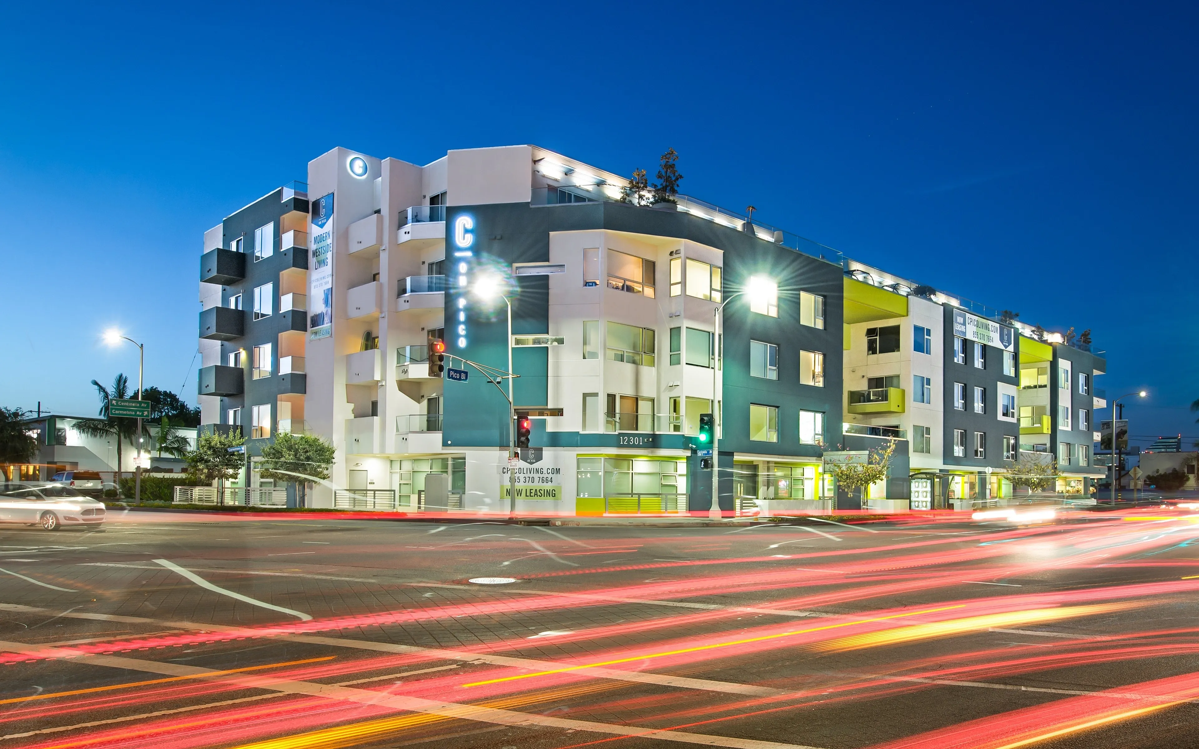 Modern apartment building with sleek architectural design illuminated at dusk, showcasing vibrant urban living.
