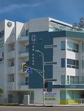 Modern apartment building featuring vibrant architecture with sleek balconies, set against a clear blue sky.
