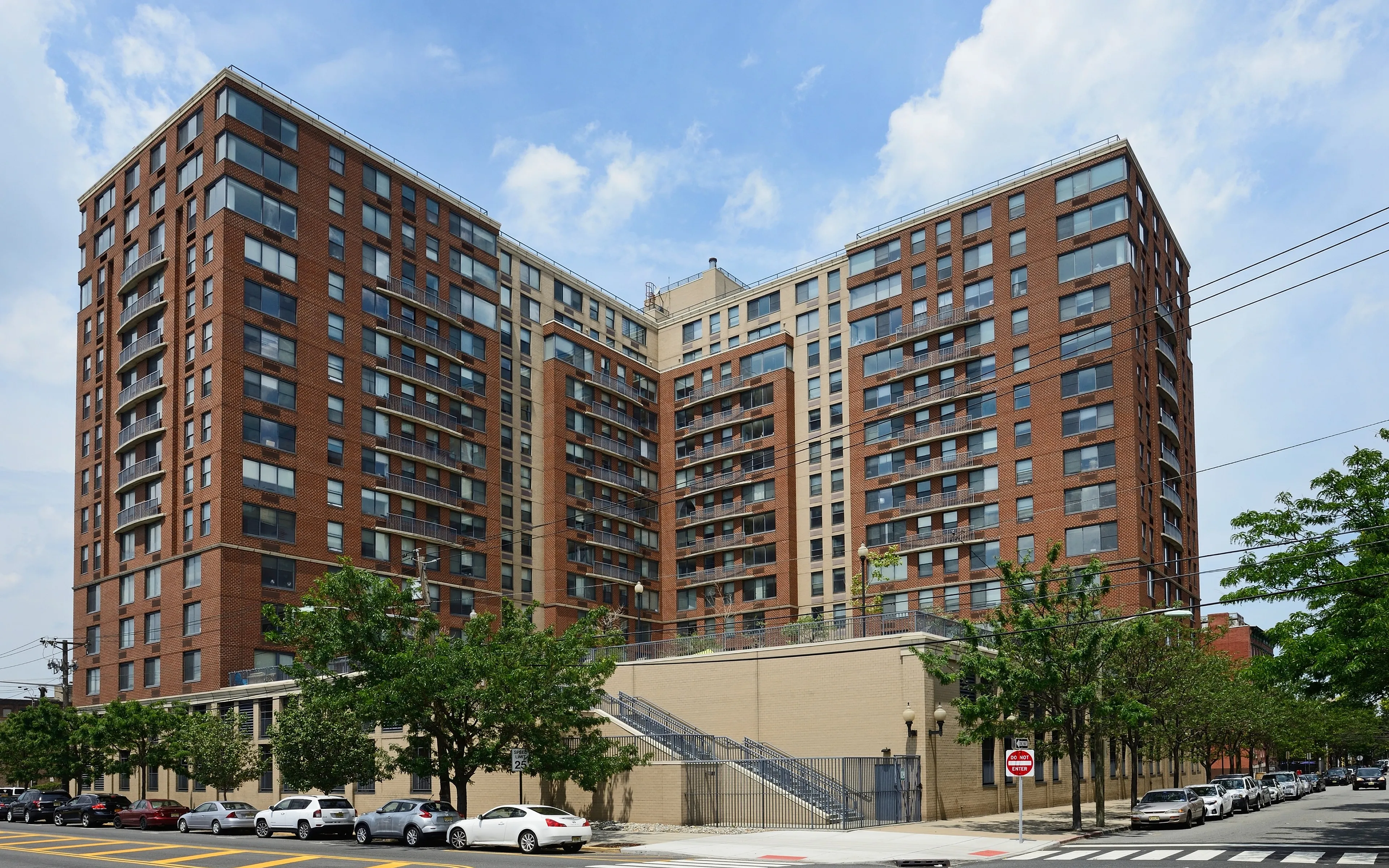 Impressive urban apartment building with modern architecture, featuring expansive windows and a spacious facade.