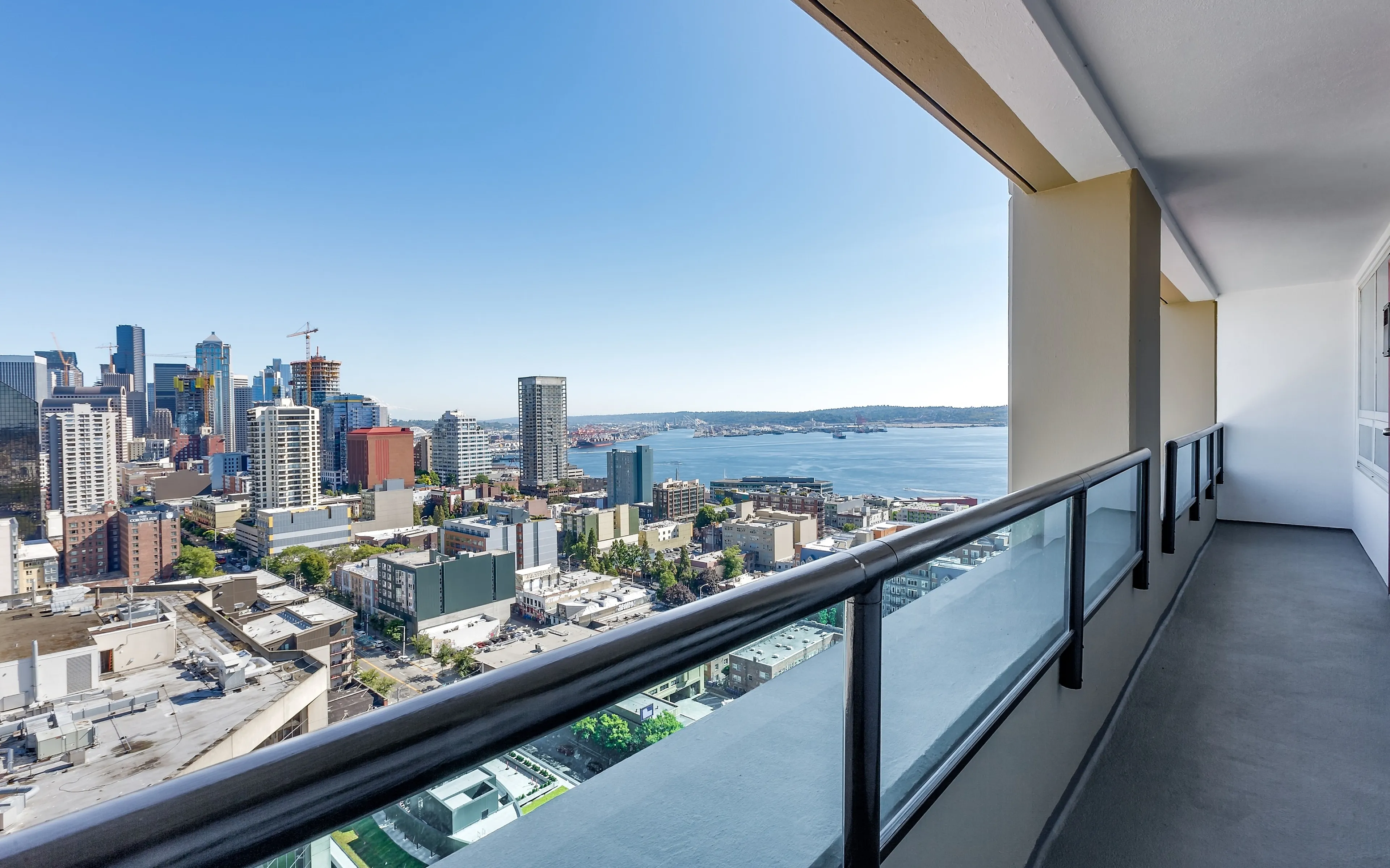Spacious balcony with stunning city and waterfront views, perfect for relaxation and entertaining.