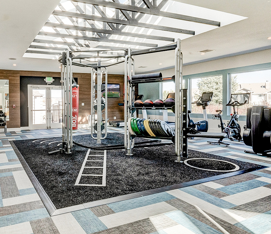 Bright and modern fitness center featuring state-of-the-art equipment, skylights, and a spacious, stylish design.