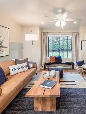 Cozy living room with stylish decor, featuring a plush leather sofa, patterned armchairs, and a warm fireplace under soft lighting.