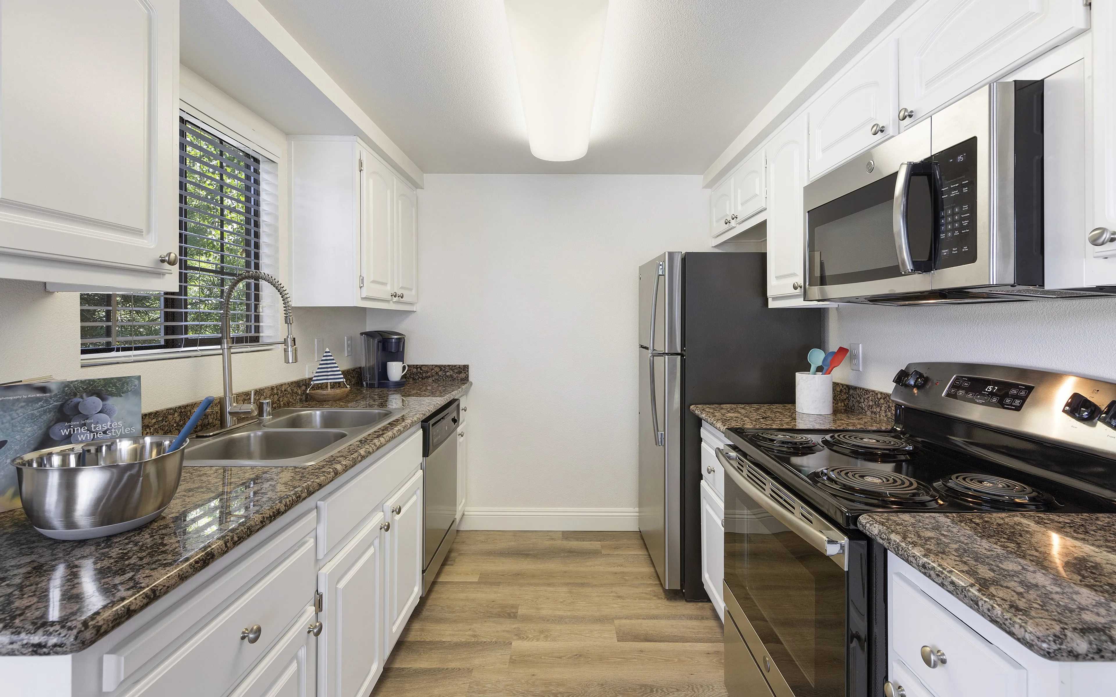 Modern kitchen with sleek stainless steel appliances, granite countertops, and elegant white cabinetry offering a bright and contemporary cooking space.