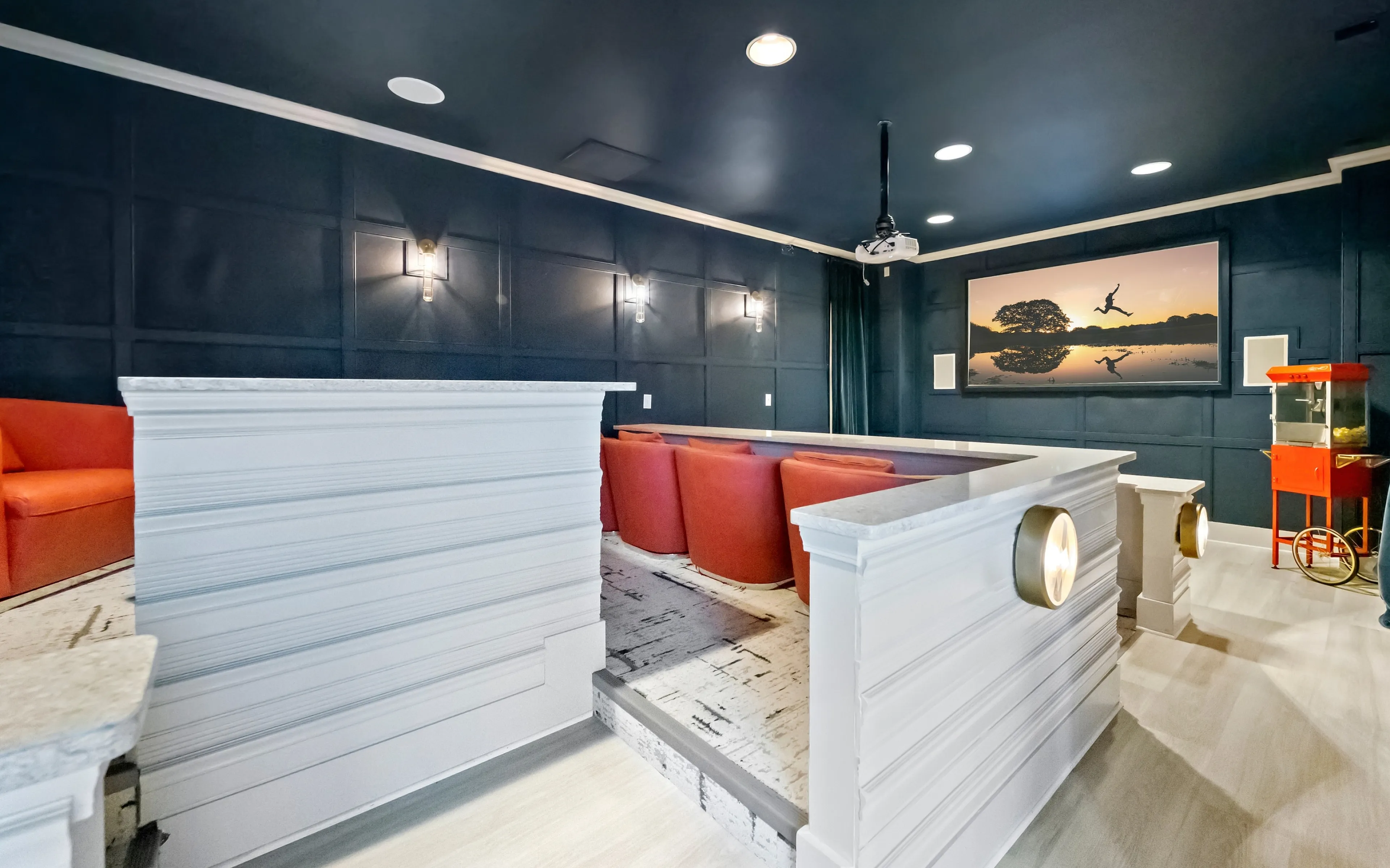 Luxurious home theater with plush red seating, modern lighting, and a large screen for an immersive movie experience.