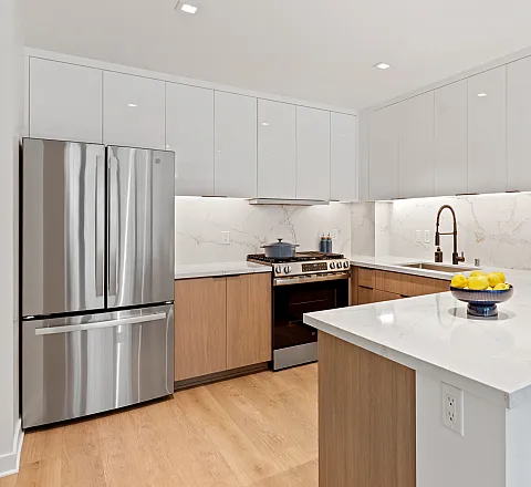 Modern kitchen with sleek countertops and stainless steel appliances, featuring ample storage and stylish lighting.