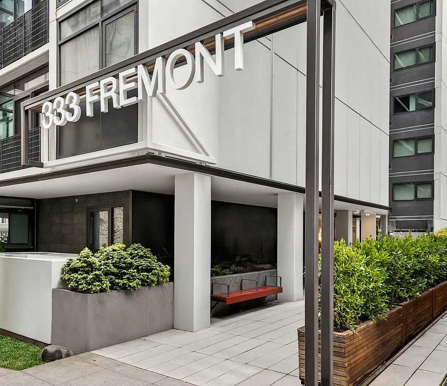 Modern urban apartment building at 333 Fremont with sleek design, lush greenery, and inviting entrance.