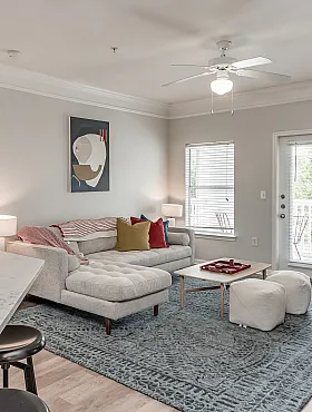 Inviting living room with a modern, open-concept design featuring a cozy sofa, stylish decor, and elegant marble countertop in a well-lit space.