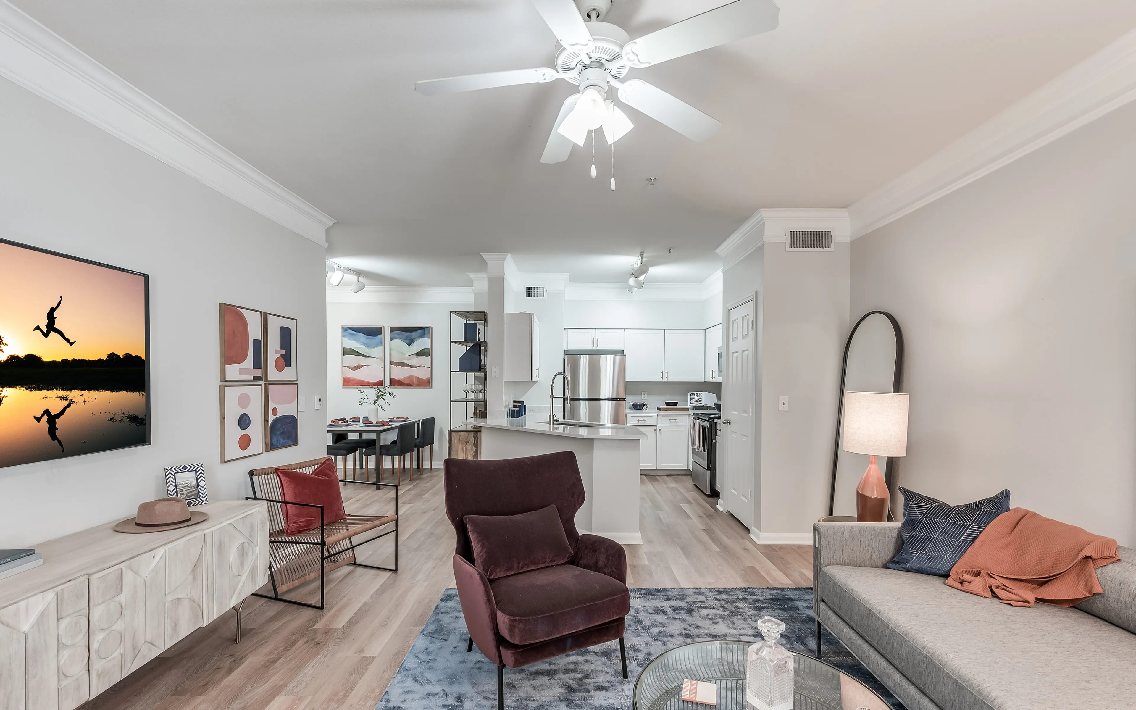 Chic open-concept apartment showcasing a cozy living area with modern decor, a stylish kitchen, and a dining space under elegant lighting.