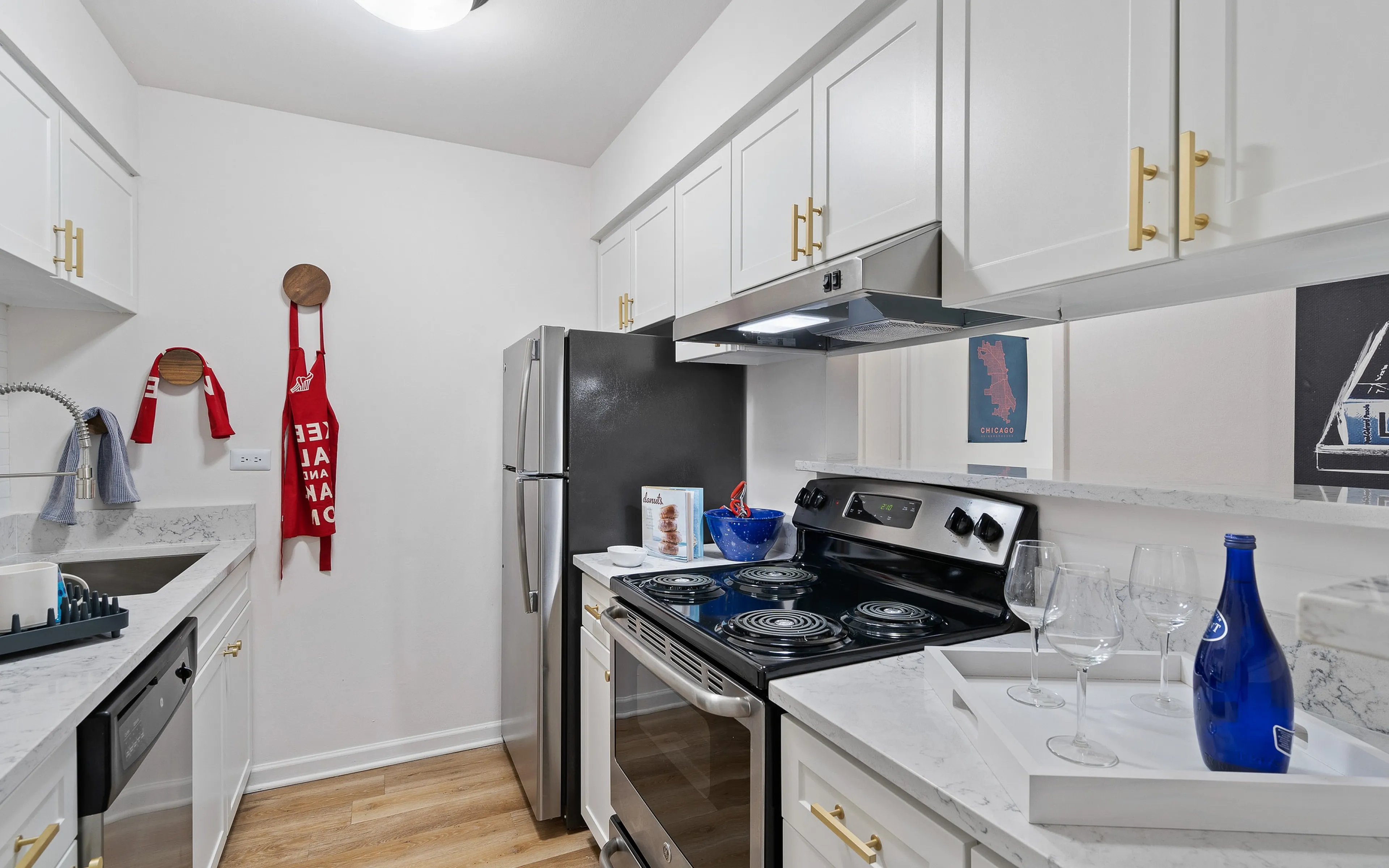 Chic kitchen with sleek white cabinetry, stainless steel appliances, and elegant marble countertops, perfect for culinary adventures.