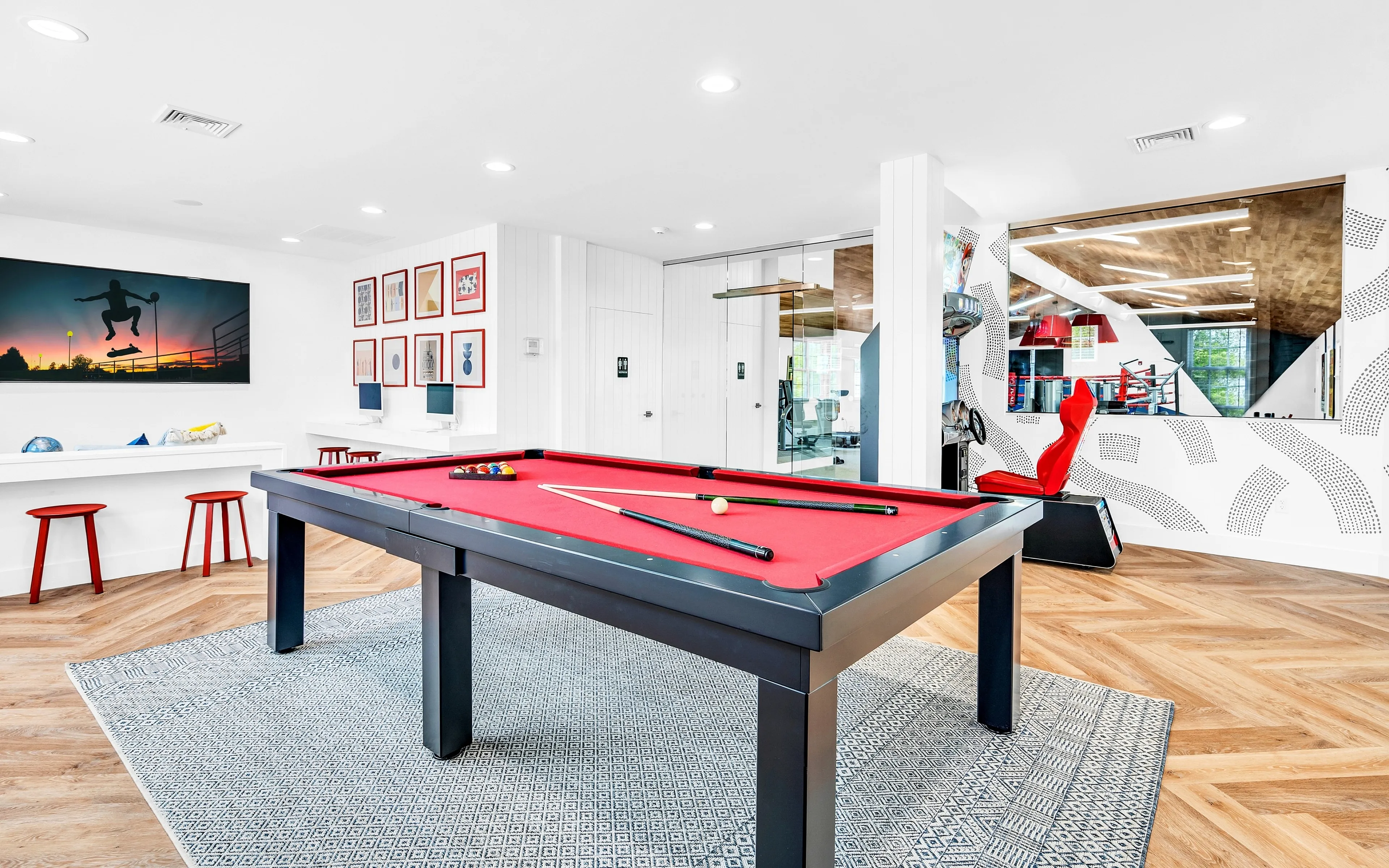 Bright and inviting recreation room featuring a vibrant red pool table, stylish modern decor, and ample natural light.