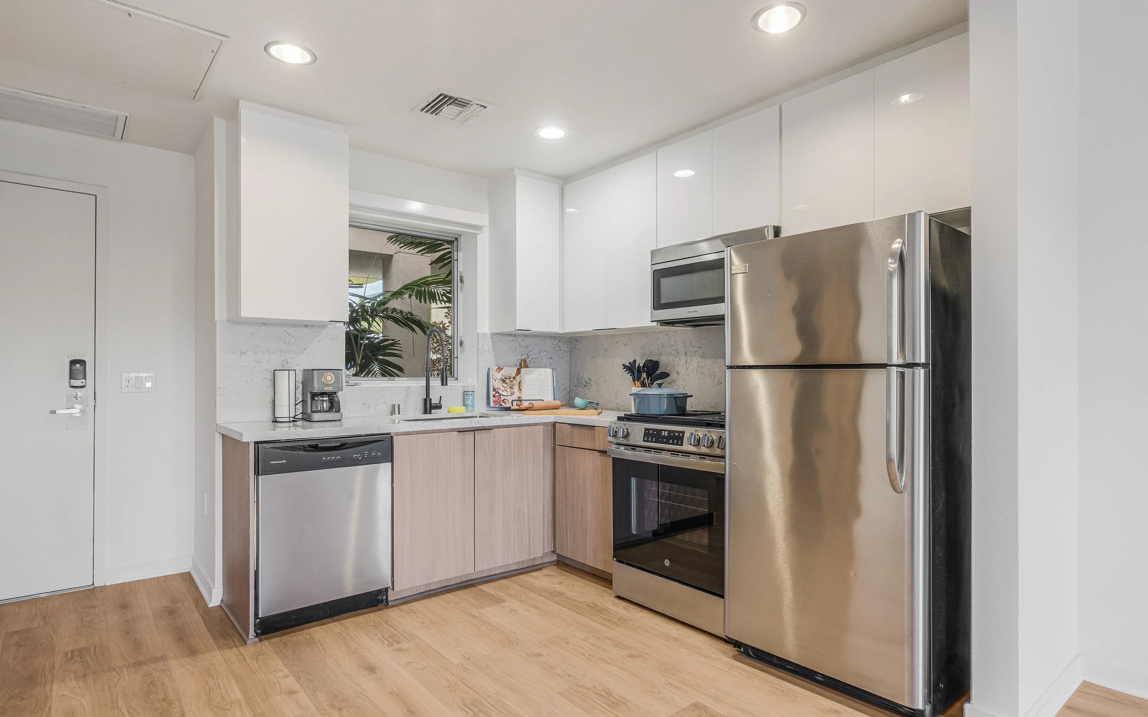 Modern kitchen with stainless steel appliances, sleek cabinetry, and wood flooring, perfect for stylish culinary creations.
