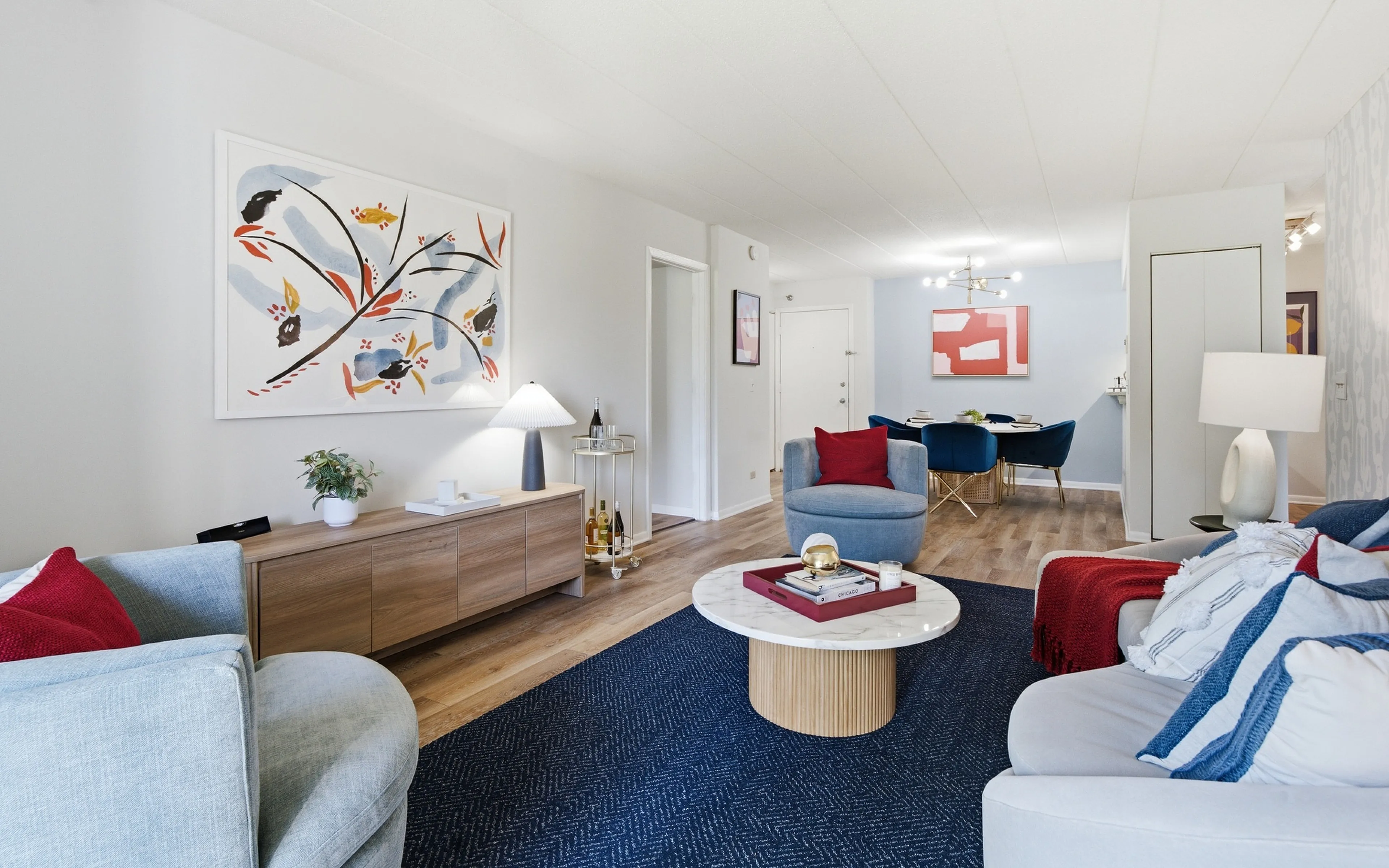 Inviting living and dining area with modern decor, showcasing comfortable seating, elegant artwork, and a chic dining set, perfect for entertaining.