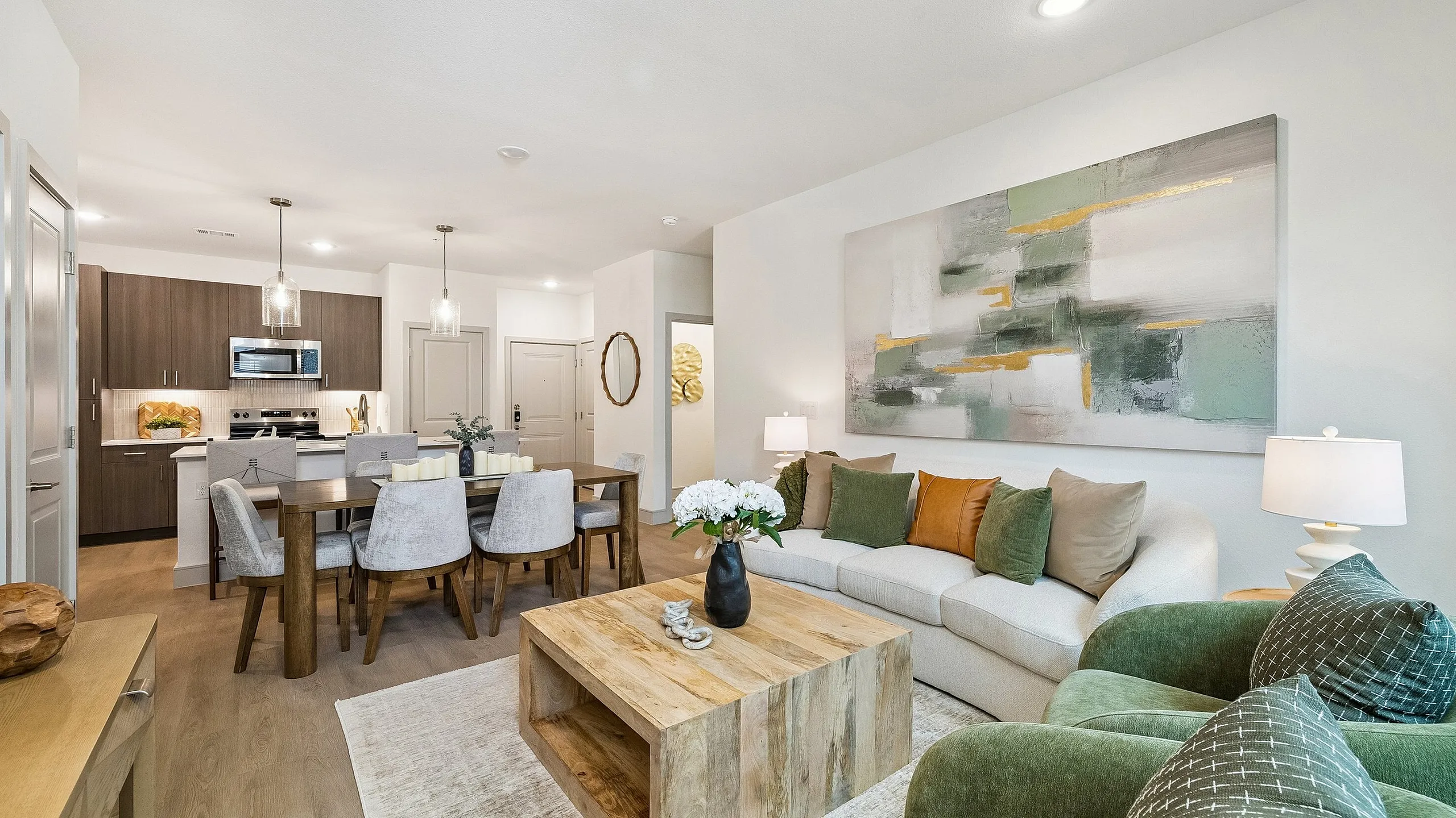 Elegant open-concept living and dining area with a modern kitchen, cozy sofa, and stylish decor.