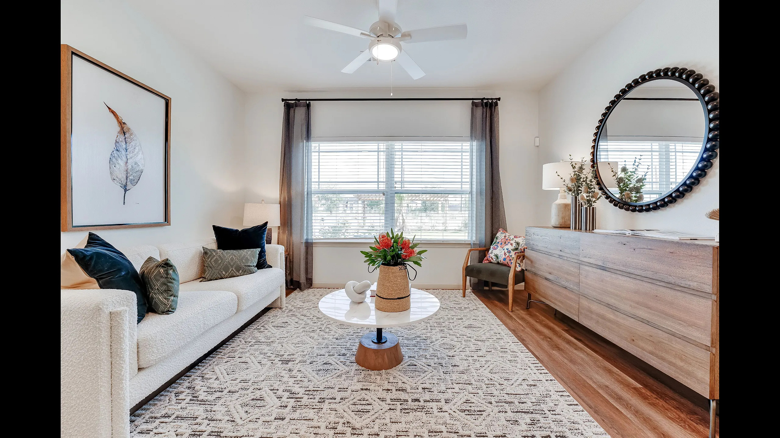 Inviting living room with natural light, plush sofa, elegant decor, and wooden accents, perfect for relaxation and style.