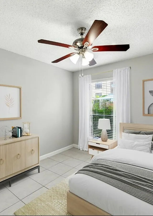 Bright and airy bedroom with stylish decor, featuring a comfortable bed, elegant ceiling fan, and contemporary artwork on pale grey walls.