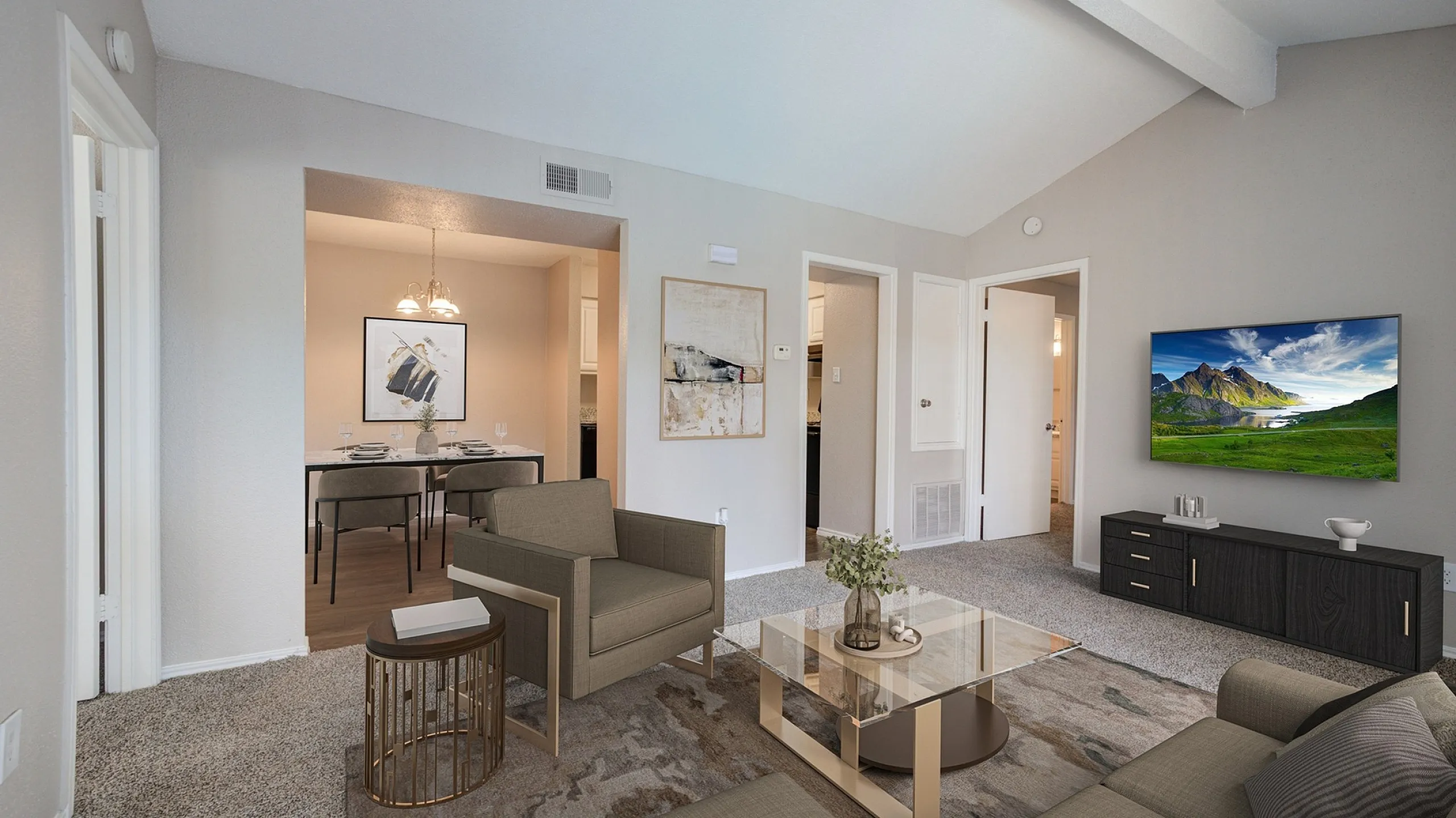 Inviting living room with modern furniture, elegant decor, and a cozy dining area, all under a vaulted ceiling.