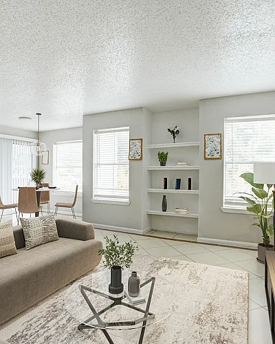 Bright and inviting open-concept living space with cozy brown sofa, stylish bar stools, and elegant dining area, perfect for modern living.
