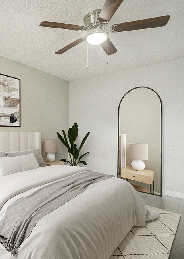 Elegant bedroom featuring a plush bed with neutral bedding, stylish nightstands, and a chic ceiling fan, enhanced by natural light.