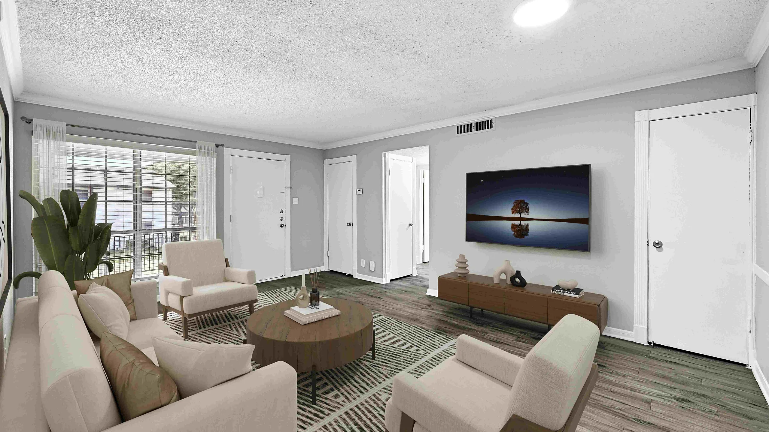 Modern living room with cozy beige sofa and armchairs, large flat-screen TV, and vibrant plants, offering a stylish and inviting atmosphere.