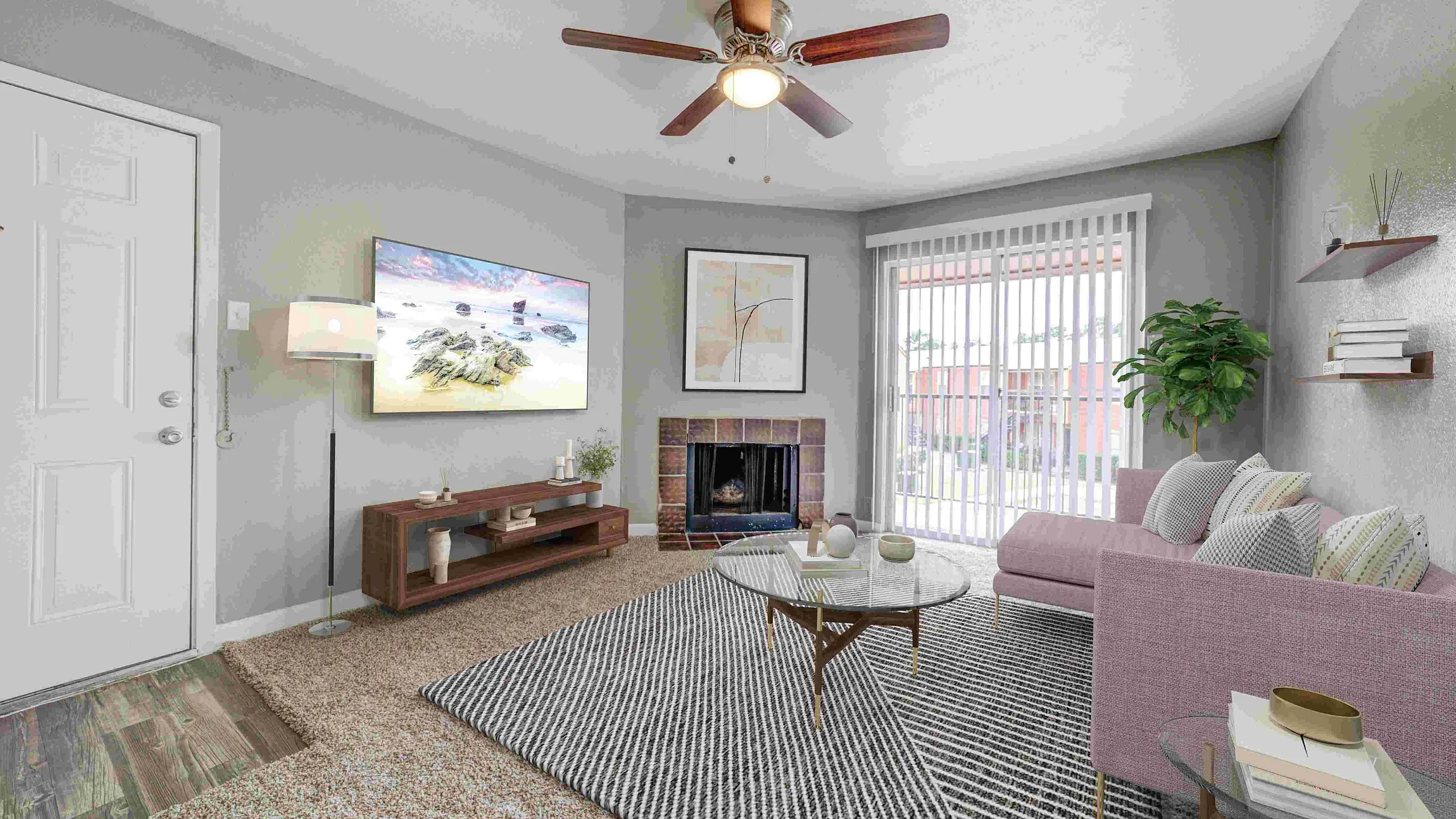 Bright and cozy living room with inviting pink sofa, stylish glass coffee table, and warm fireplace, set against a backdrop of large windows with city views.