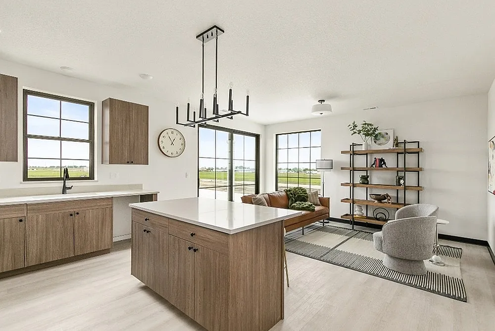 Modern open-concept living space with chic kitchen island, stylish chandelier, and cozy seating area overlooking scenic views.