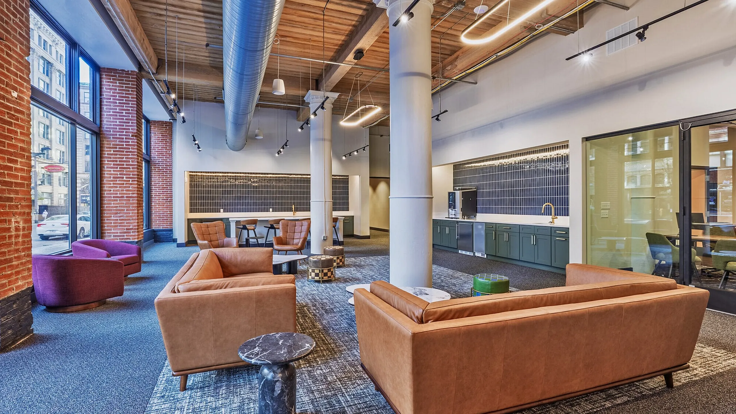 Sophisticated urban lounge with modern furniture, exposed brick walls, and large windows offering city views.