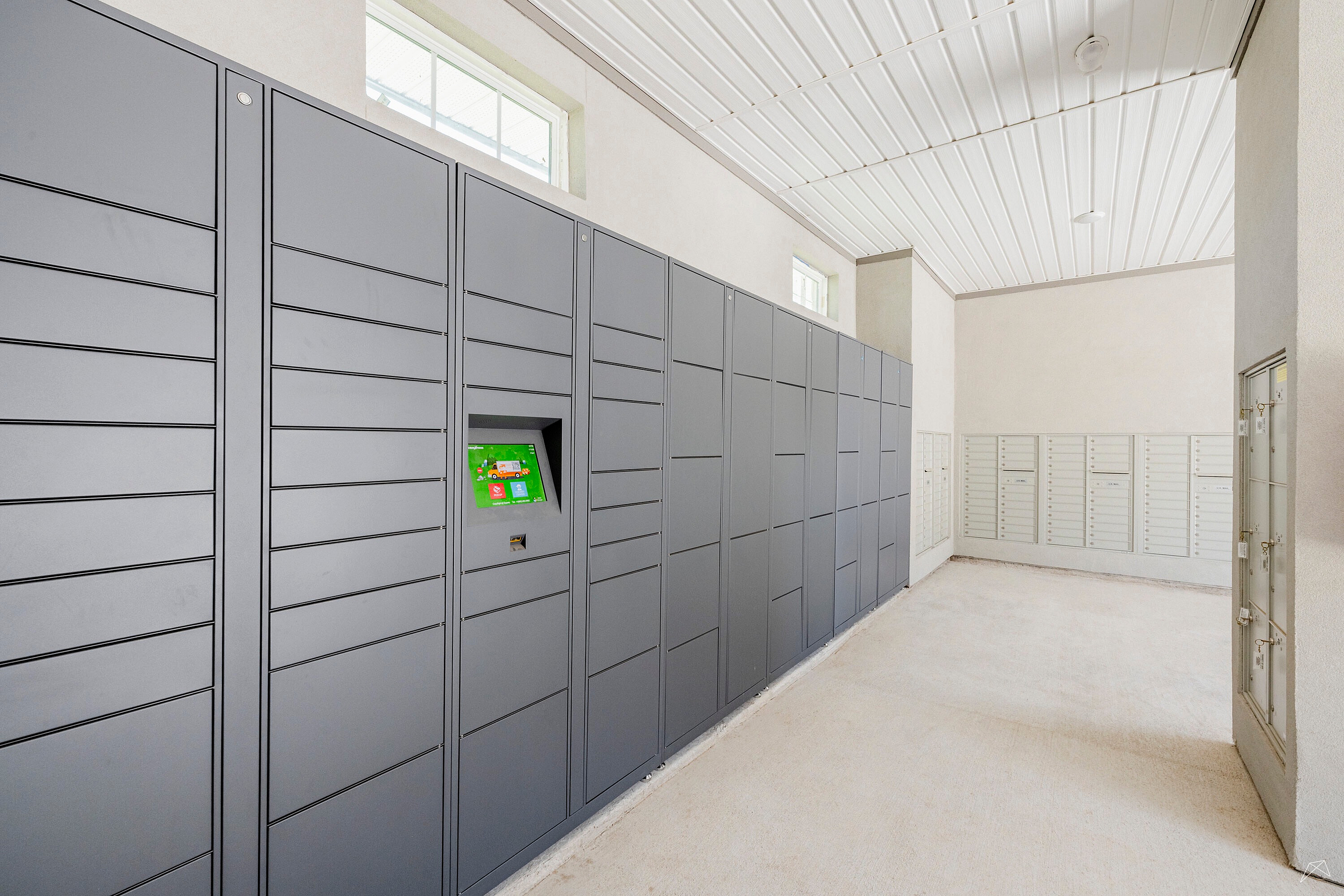 Modern package delivery room featuring sleek, secure lockers and natural lighting, ideal for convenient living.