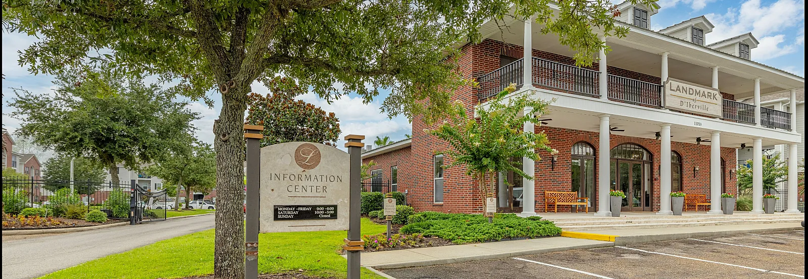 Elegant entrance to an information center with a red brick facade and inviting greenery.