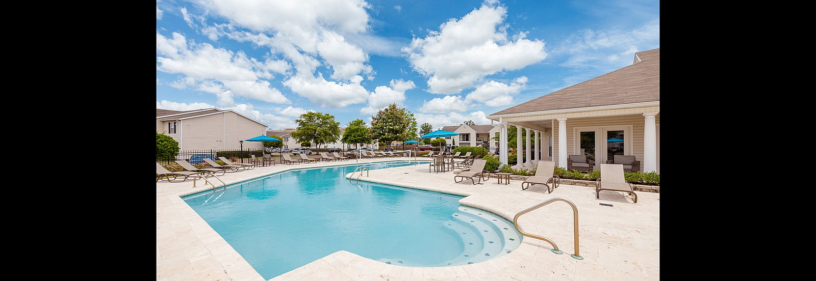 Inviting swimming pool surrounded by sun loungers and lush greenery, perfect for relaxation.